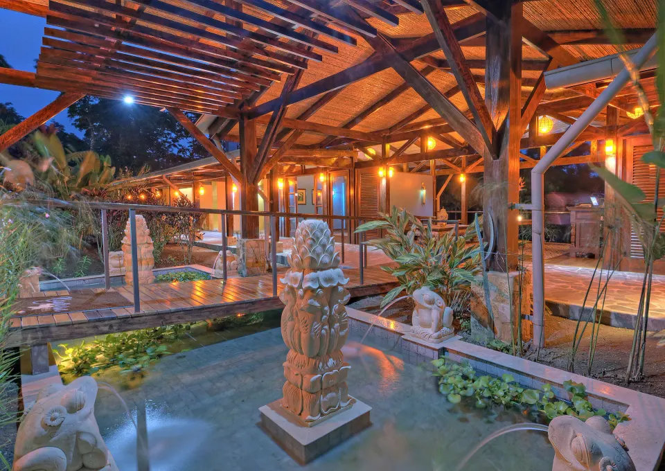 Evening spa courtyard with reflecting pools and sculptures at Nayara Springs.