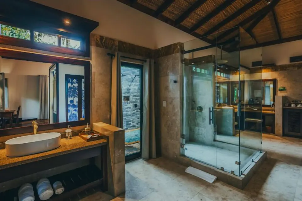 Spacious bathroom with glass shower and double vanity at Nayara Springs.