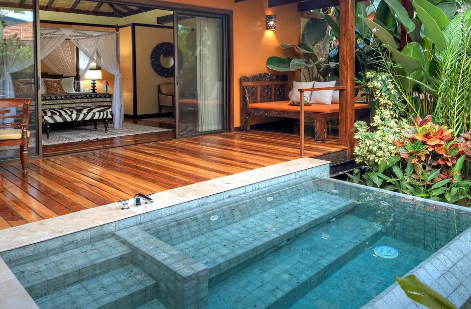 Private plunge pool and terrace outside a canopy-bed villa at Nayara Springs.