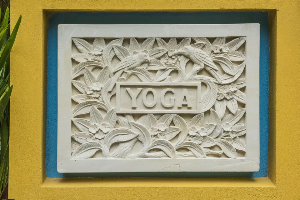 Carved yoga sign with tropical leaf details at Nayara Springs.