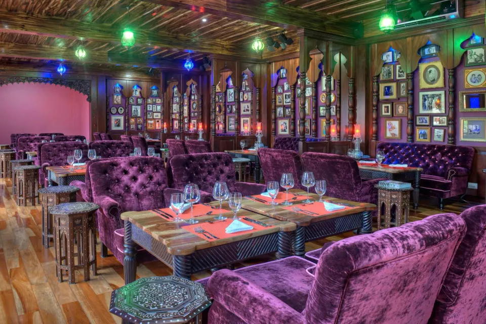 Colorful lounge-style dining room with set tables at Nayara Springs.