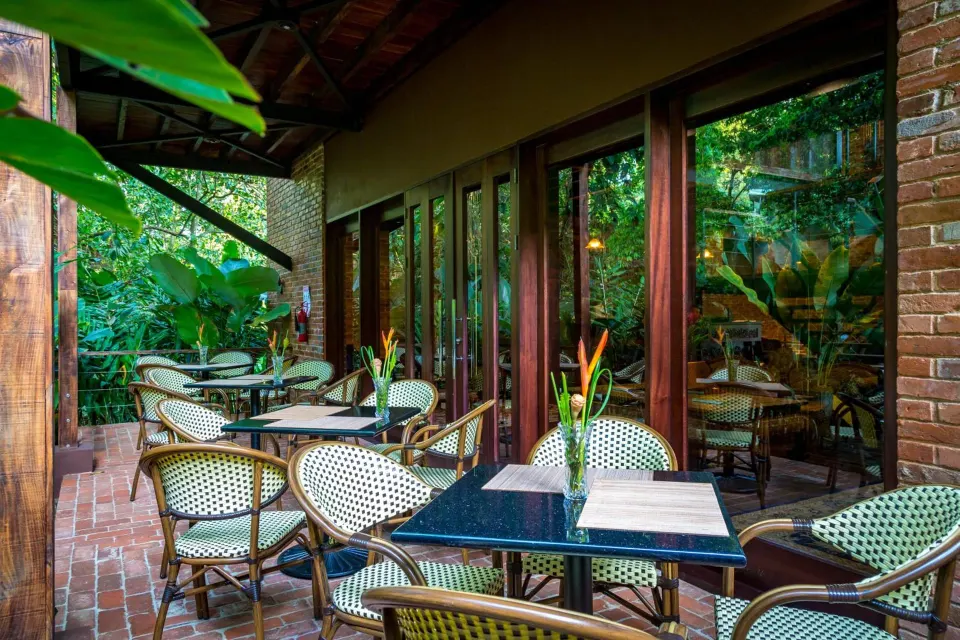 Covered terrace seating with bistro chairs at Nayara Springs.