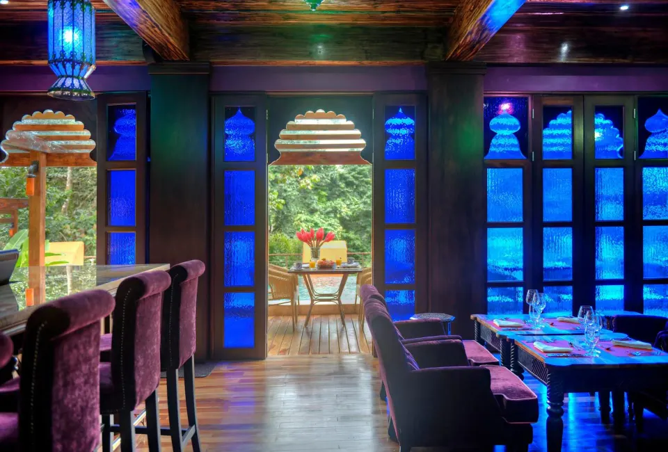 Dining room with blue stained glass and terrace view at Nayara Springs.