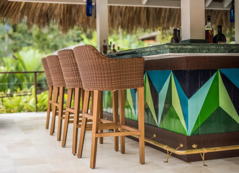 Woven bar stools line a geometric painted bar at Nayara Springs.