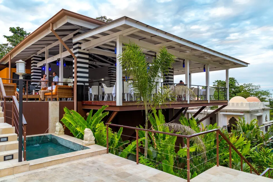 An elevated open-air bar terrace overlooks greenery at Nayara Springs.