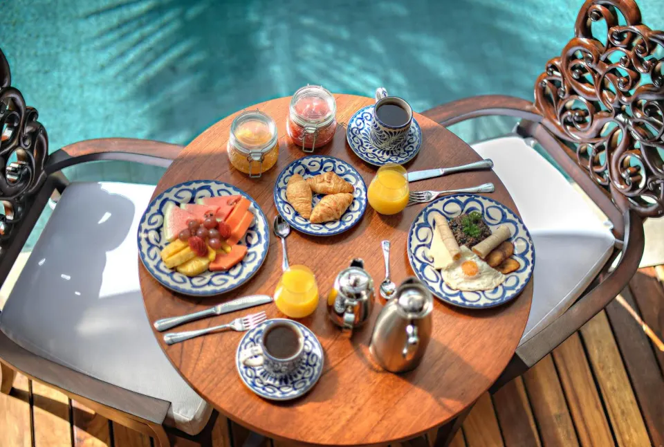 Poolside breakfast set for two beside blue water at Nayara Springs.
