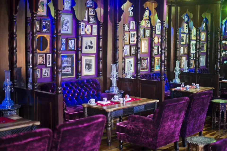 Purple banquettes and framed wall art in a dining room at Nayara Springs.