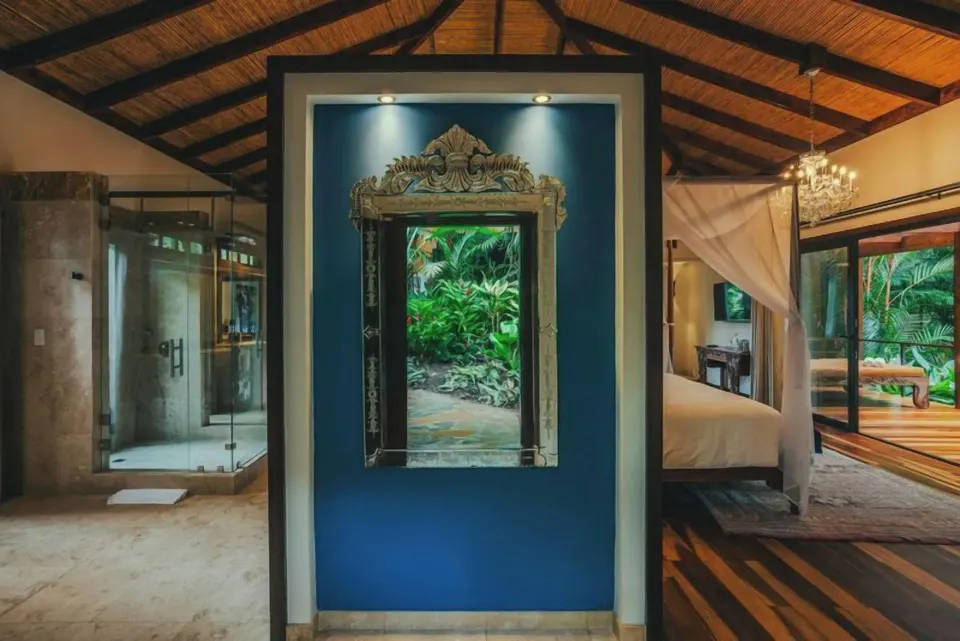 Springs Villa interior with bath area, mirror, and bedroom beyond at Nayara Springs.