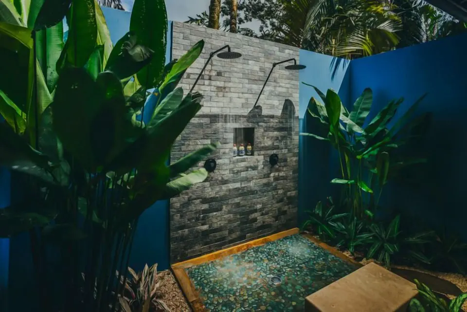 Springs Villa outdoor shower with blue walls and tropical plants at Nayara Springs.