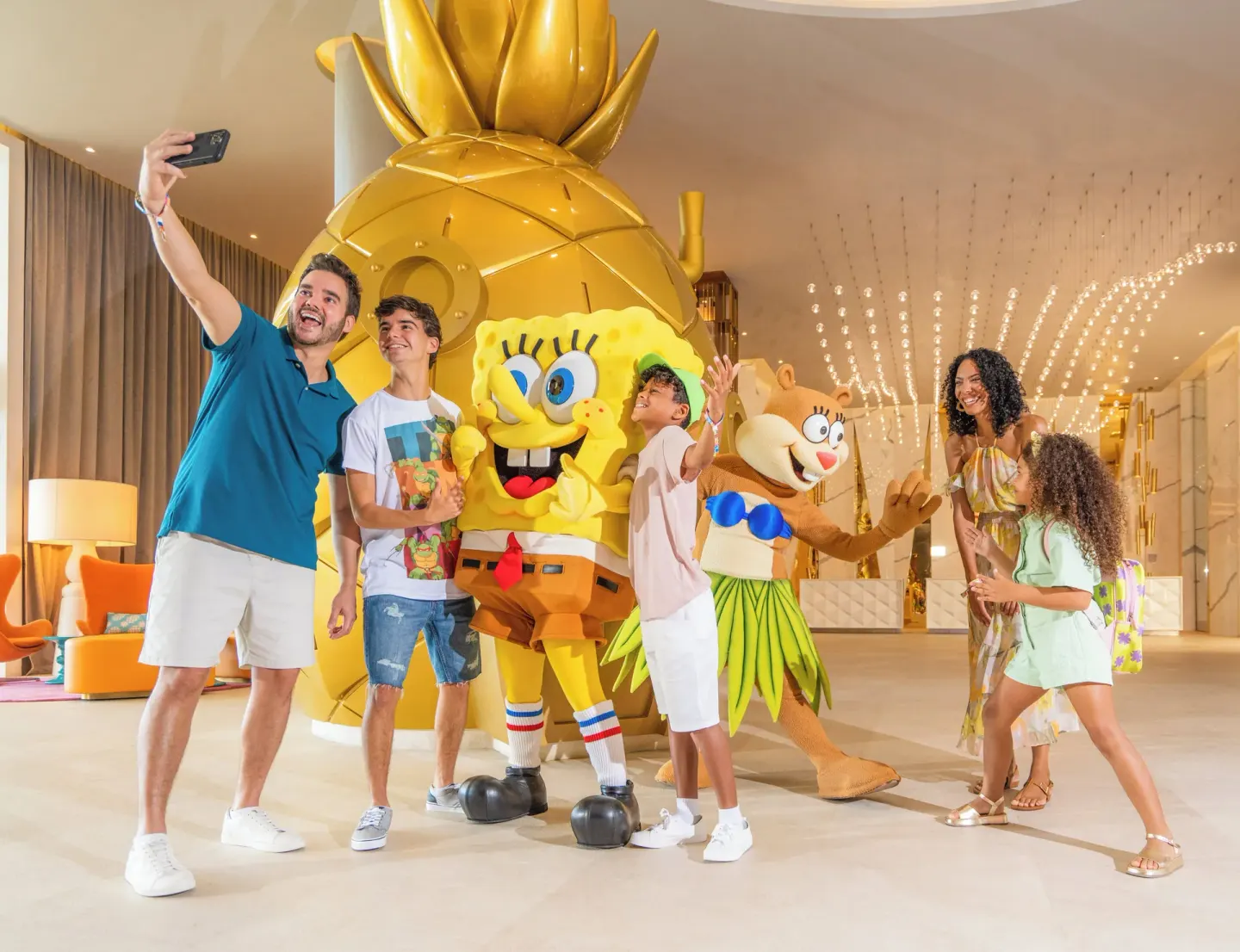 Family taking a selfie with costumed characters in the lobby at Nickelodeon Hotels & Resorts Riviera Maya.