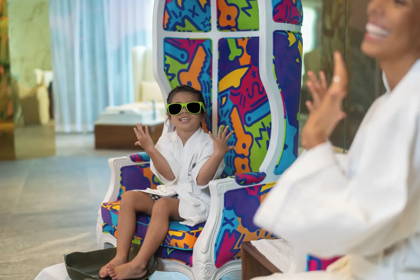 A child in a robe sits on a colorful spa chair at Nickelodeon Hotels & Resorts Riviera Maya.