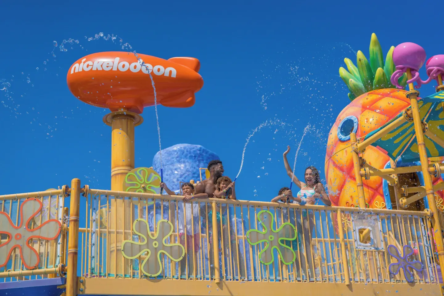 Guests stand on an elevated splash deck at Nickelodeon Hotels & Resorts Riviera Maya.