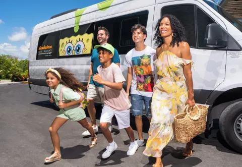 Family walking beside a branded shuttle van at Nickelodeon Hotels & Resorts Riviera Maya.