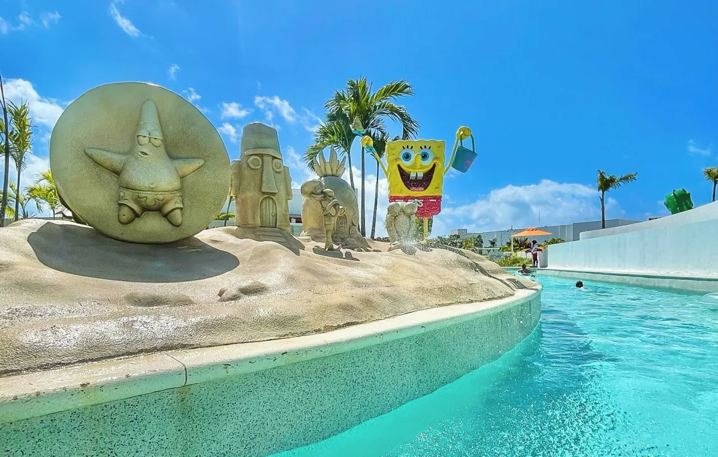 Lazy river curves past sand-style character sculptures at Nickelodeon Hotels & Resorts Riviera Maya.
