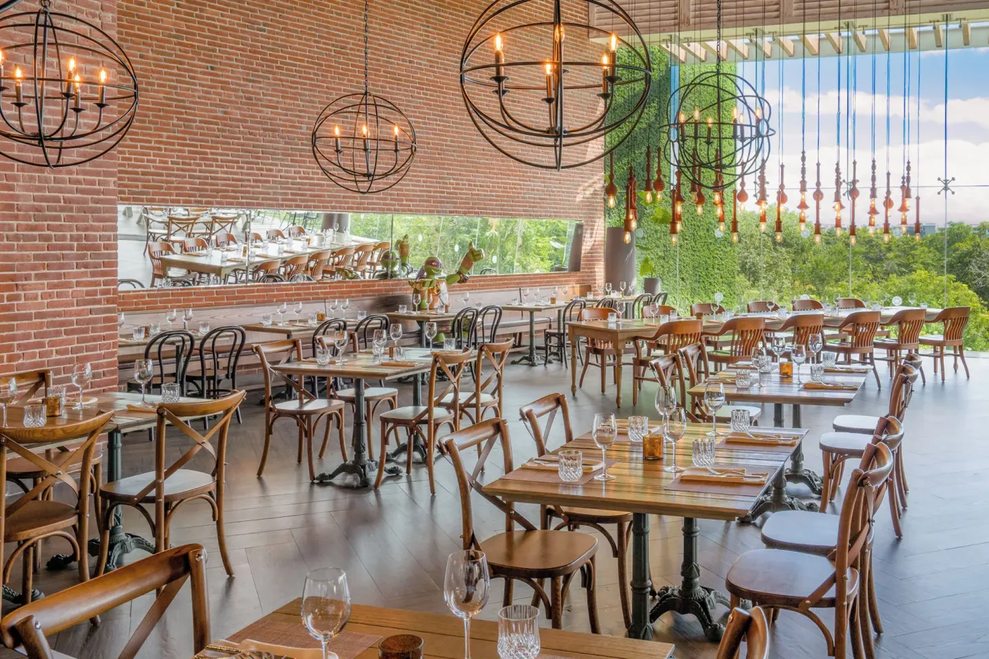 Brick-walled restaurant dining room with set tables at Nickelodeon Hotels & Resorts Riviera Maya.