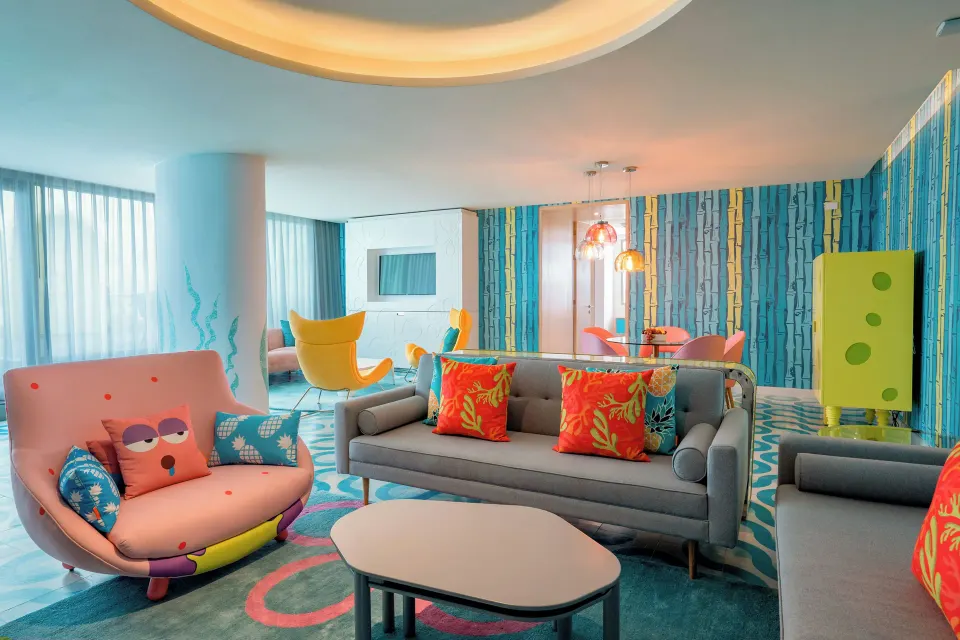 Pineapple Suite living room with colorful sofas at Nickelodeon Hotels & Resorts Riviera Maya.