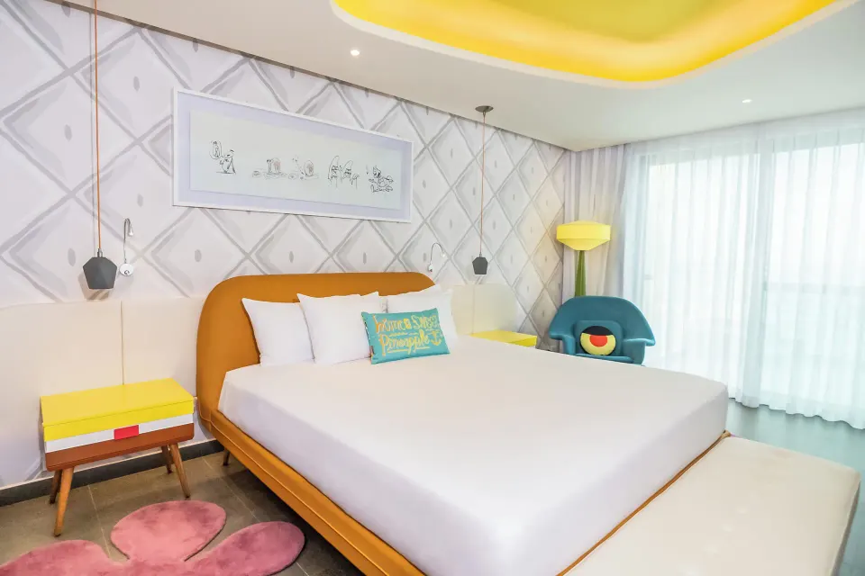 Pineapple Suite bedroom with orange bed frame at Nickelodeon Hotels & Resorts Riviera Maya.