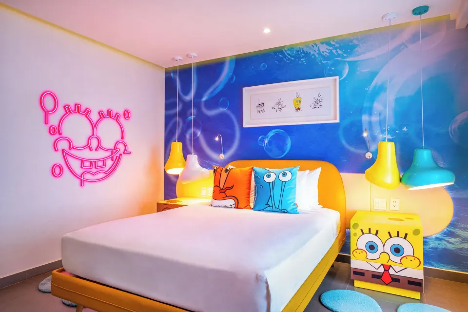 Pineapple Suite bedroom with bubble mural and neon face at Nickelodeon Hotels & Resorts Riviera Maya.