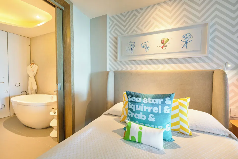 Oceanfront Swim-Up Suite bed beside open bathroom at Nickelodeon Hotels & Resorts Riviera Maya.