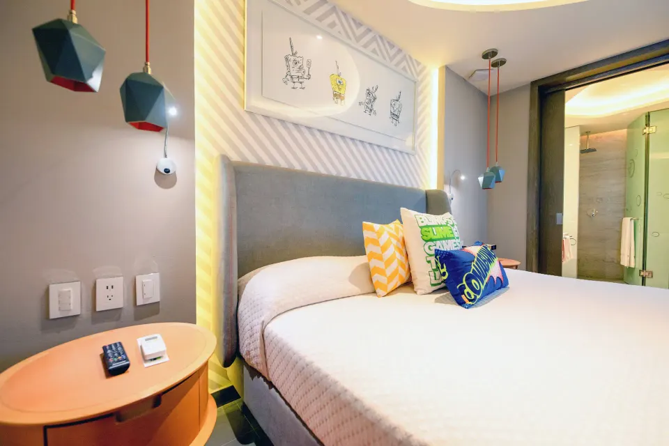 Oceanfront Swim-Up Suite king bed and bedside table at Nickelodeon Hotels & Resorts Riviera Maya.