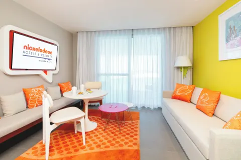 Oceanfront Swim-Up Suite sitting area with sofa at Nickelodeon Hotels & Resorts Riviera Maya.