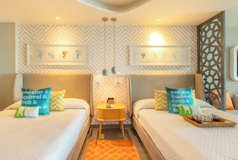 Oceanfront Swim-Up Suite bedroom with two beds at Nickelodeon Hotels & Resorts Riviera Maya.