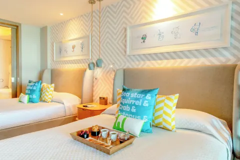 Oceanfront Swim-Up Suite bedroom with two beds at Nickelodeon Hotels & Resorts Riviera Maya.