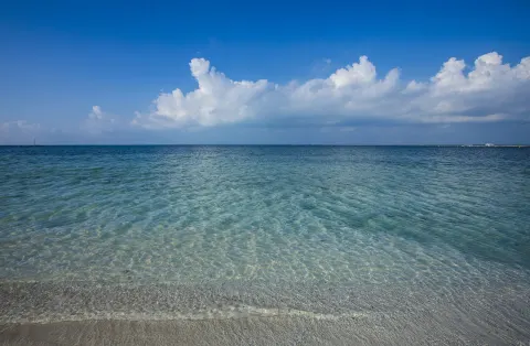 Clear shallow shoreline water beneath a blue sky at Nizuc Resort and Spa.
