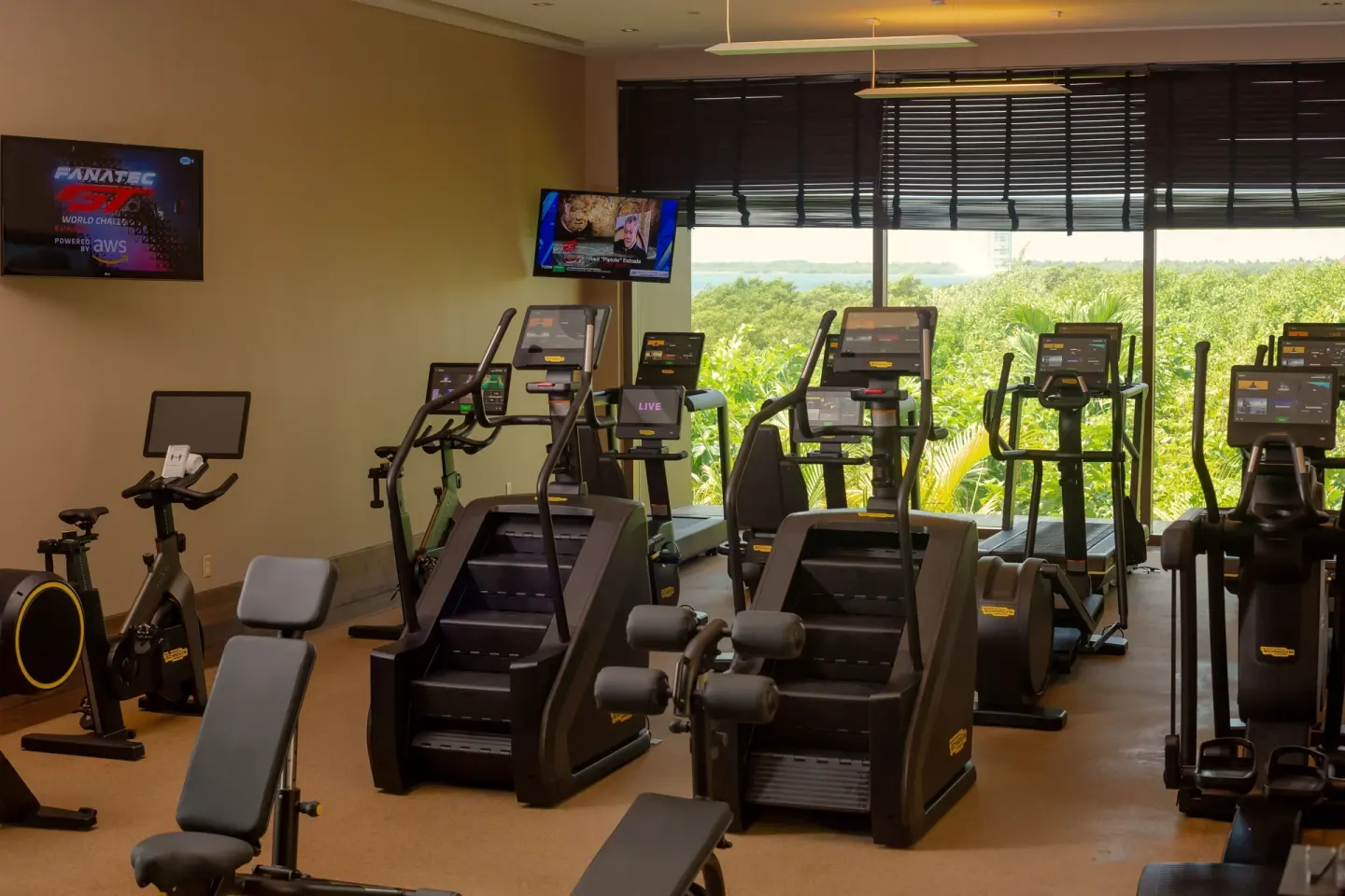 Fitness room with cardio machines and large windows at Nizuc Resort and Spa.