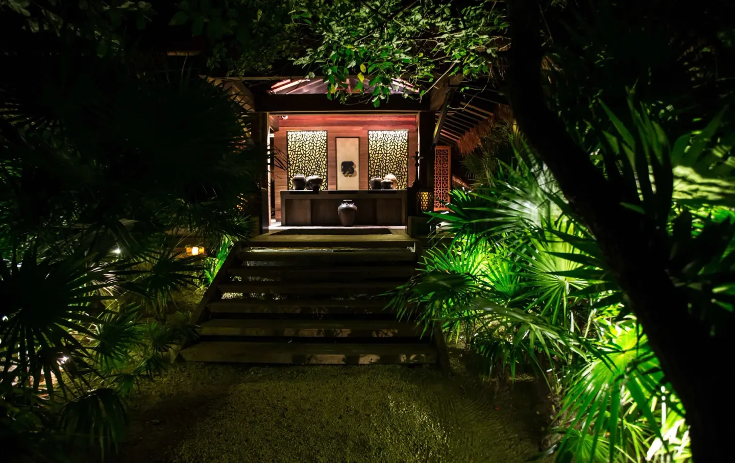 Illuminated garden walkway leading to a pavilion at Nizuc Resort and Spa.