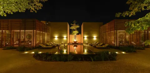 Nighttime spa courtyard with reflecting pool and loungers at Nizuc Resort and Spa.