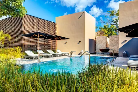 Spa pool with sun loungers, umbrellas, and tropical landscaping at Nizuc Resort and Spa.