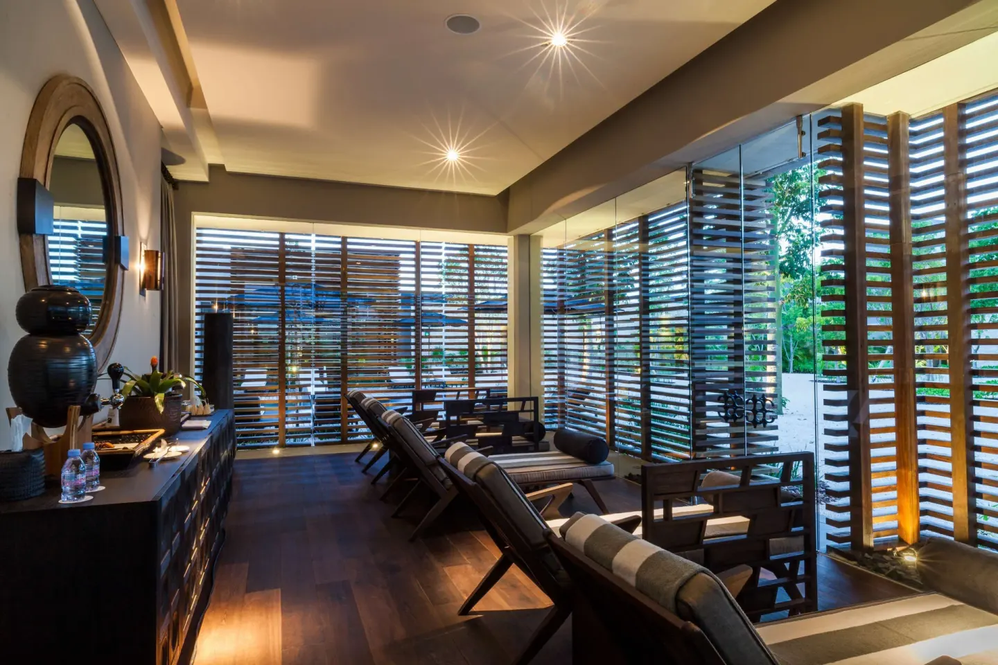 Spa relaxation lounge with reclining chairs and wooden screens at Nizuc Resort and Spa.