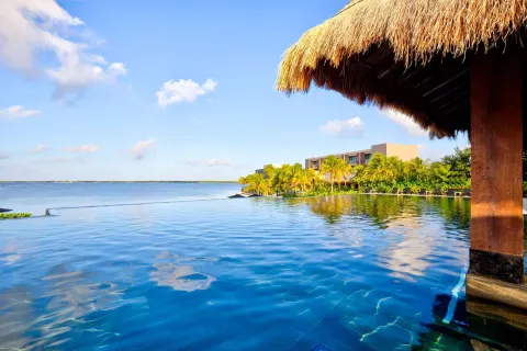 Infinity pool under a thatched roof edge at Nizuc Resort and Spa.