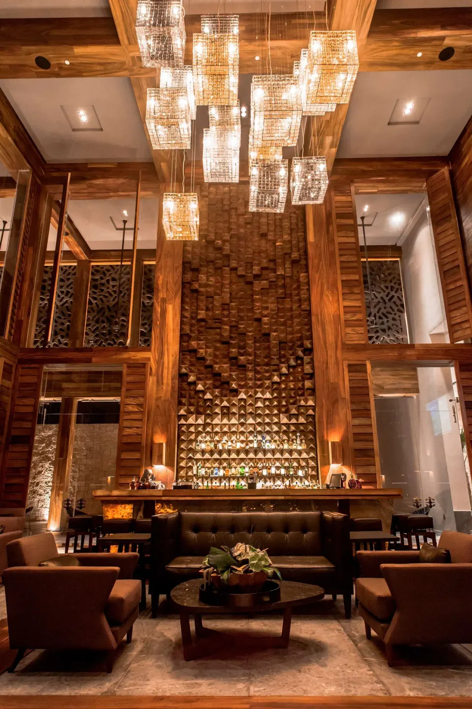 Lounge seating and a tall backlit bar wall at Nizuc Resort and Spa.