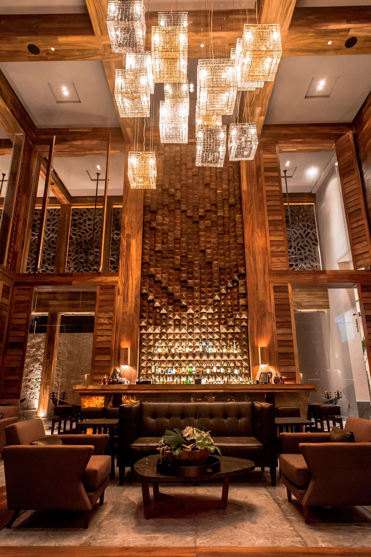 Lounge seating and a tall backlit bar wall at Nizuc Resort and Spa.