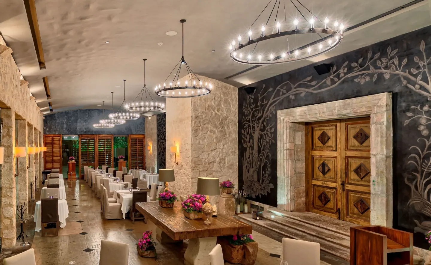 Elegant stone-walled dining room with chandeliers at Nizuc Resort and Spa.