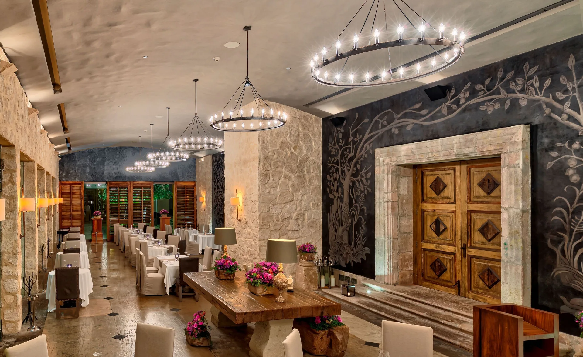 Elegant stone-walled dining room with chandeliers at Nizuc Resort and Spa.