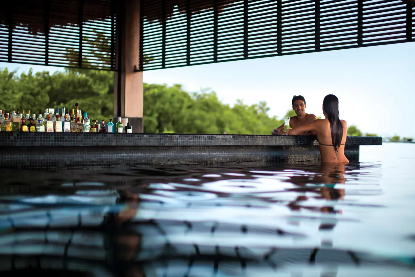Swim-up bar with guests in the pool at Nizuc Resort and Spa.