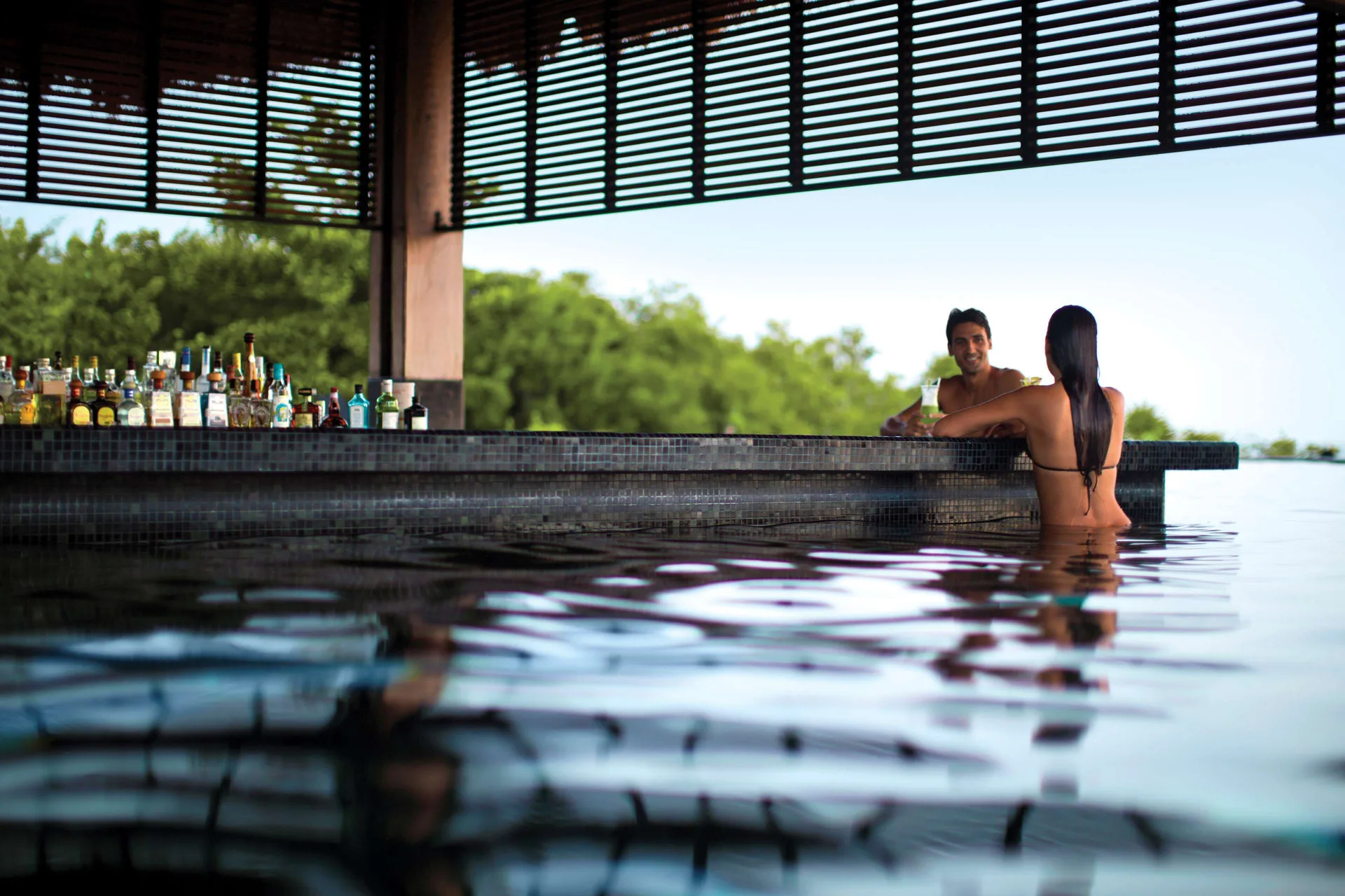 Swim-up bar with guests in the pool at Nizuc Resort and Spa.