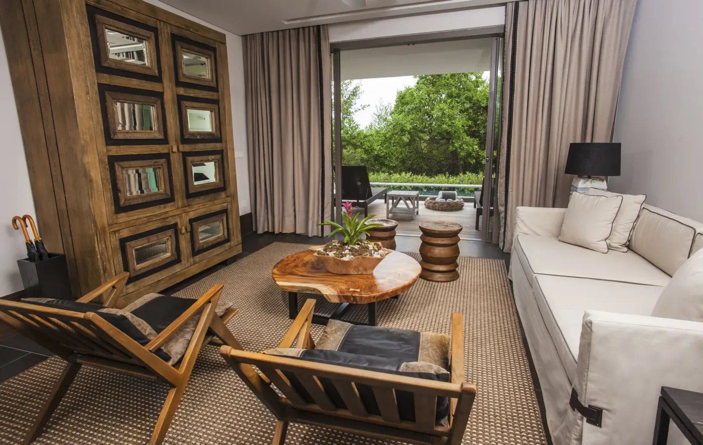 Garden Deluxe Suite living room with sofa, chairs, and terrace at Nizuc Resort and Spa.