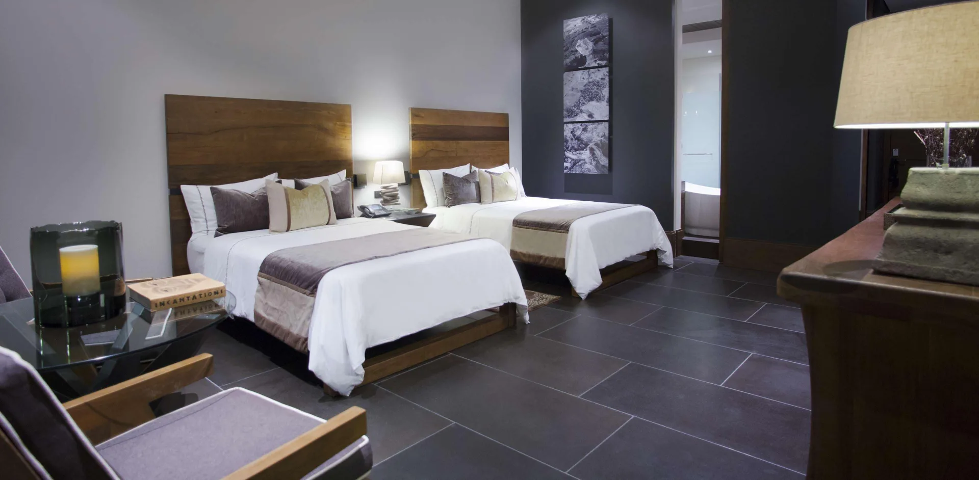A Garden View room with two beds, armchair, table, and console at Nizuc Resort and Spa.