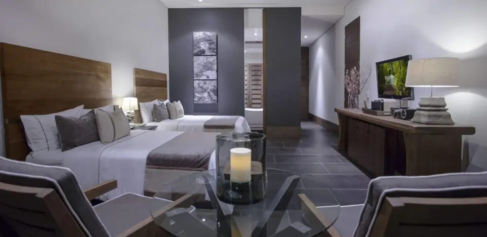A Garden View room with two beds, seating, TV, and console at Nizuc Resort and Spa.