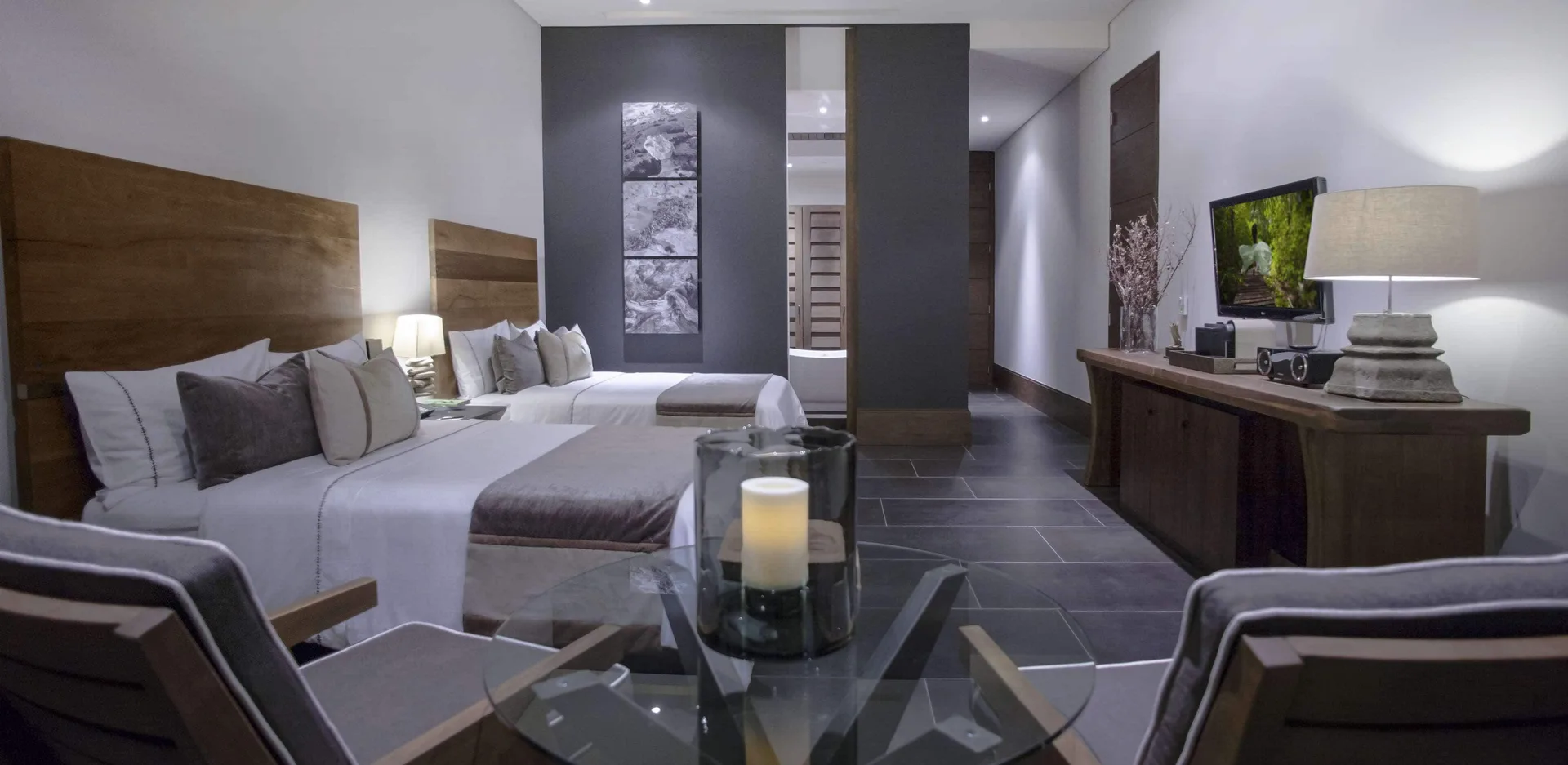 A Garden View room with two beds, seating, TV, and console at Nizuc Resort and Spa.