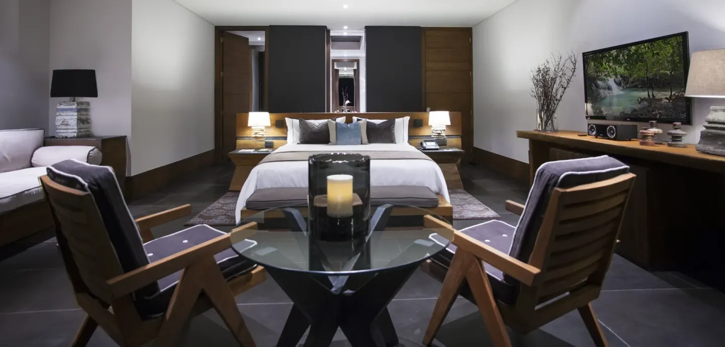Junior Suite garden king bed with armchairs and media console at Nizuc Resort and Spa.