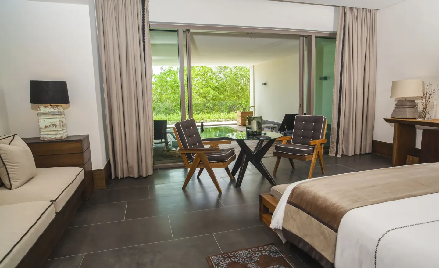 Junior Suite garden bedroom opening to a terrace and greenery at Nizuc Resort and Spa.
