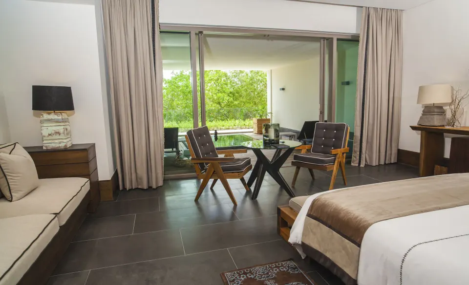 Junior Suite garden bedroom opening to a terrace and greenery at Nizuc Resort and Spa.