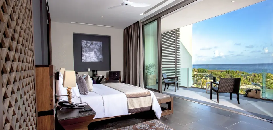 Ocean Suite king bedroom opening to an ocean-view terrace at Nizuc Resort and Spa.