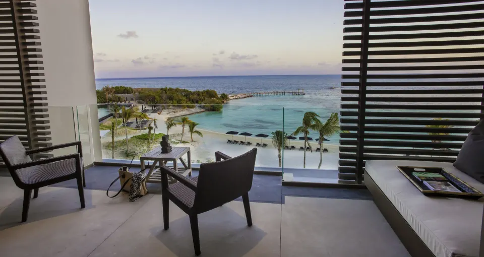Ocean Suite terrace with chairs, daybed, and Caribbean view at Nizuc Resort and Spa.