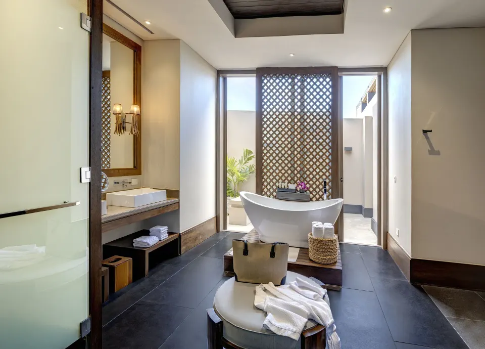 Penthouse bathroom with freestanding tub, vanity and patio light at Nizuc Resort and Spa.